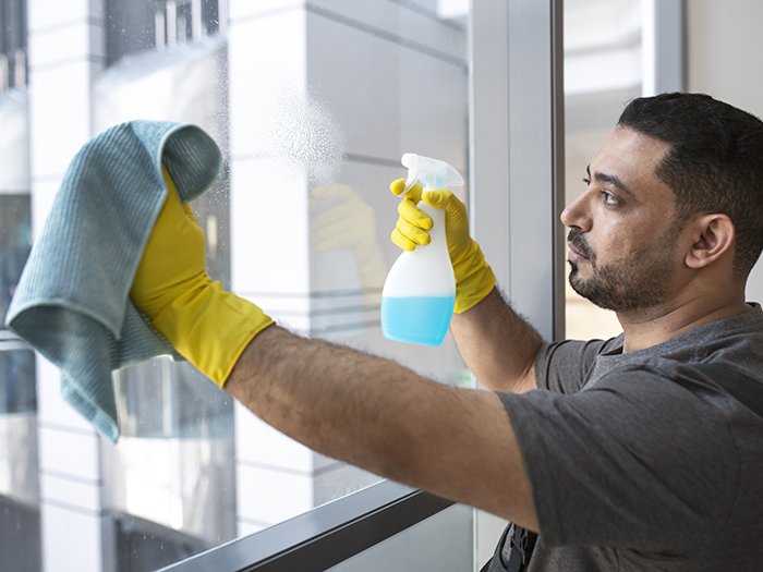 medium-shot-man-cleaning-office-window.webp